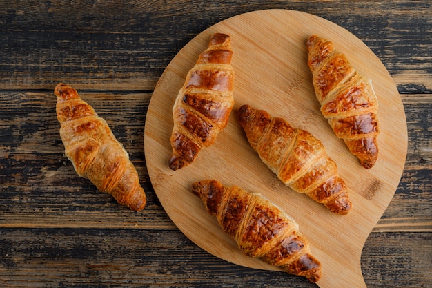 Croissant auf Holz und Schneidebrett. flach liegen.