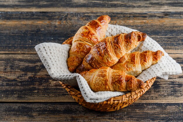 Croissant in einem Korb auf Holztisch, hohe Winkelansicht.