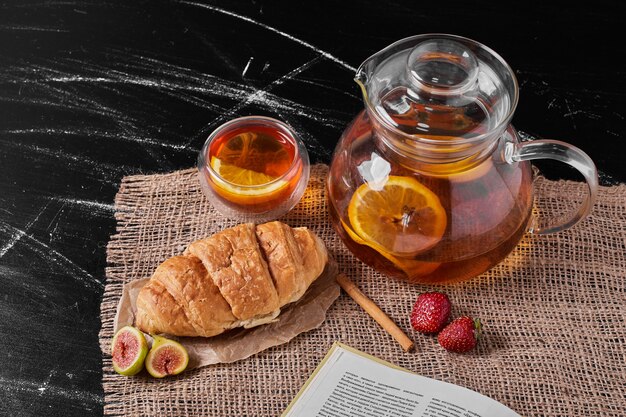 Croissant mit Limonade auf schwarz.