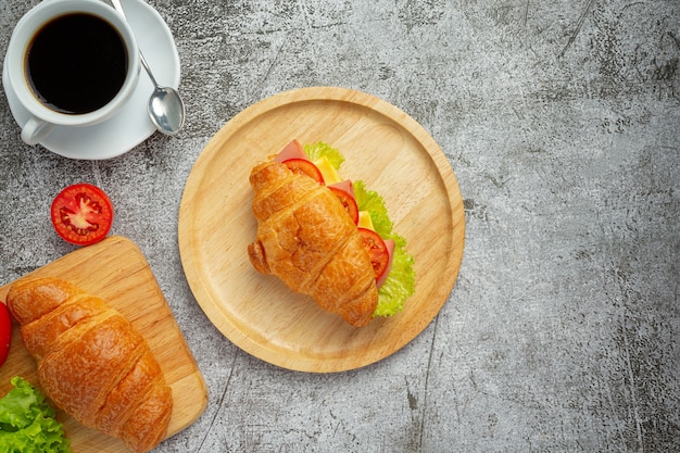 Kostenloses Foto croissant-sandwiches auf dunkler holzoberfläche