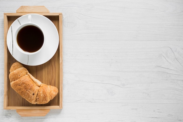 Croissant und Kaffee auf Tablett