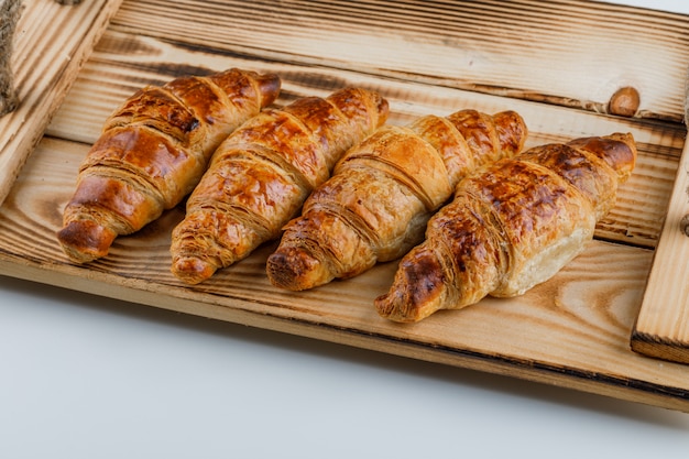 Croissants in einem Holztablett.