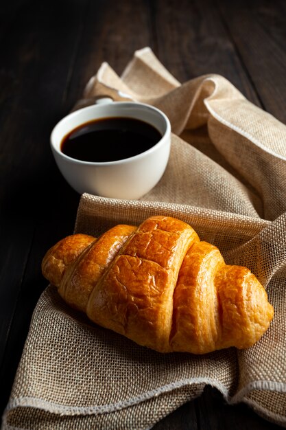 Croissants und Kaffee auf alten Holztisch.