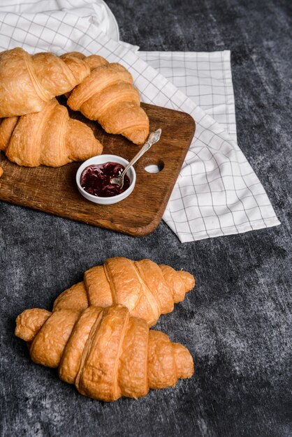 Croissants und Topf mit Marmelade beiseite auf grauem Tisch
