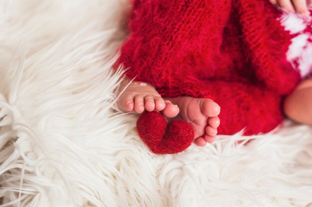 Crop Baby Füße mit roten Herzen in der Nähe