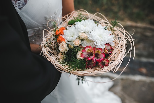 Crop bräutigam umarmen braut mit bouquet