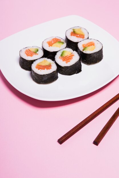 Crop Essstäbchen in der Nähe von Sushi