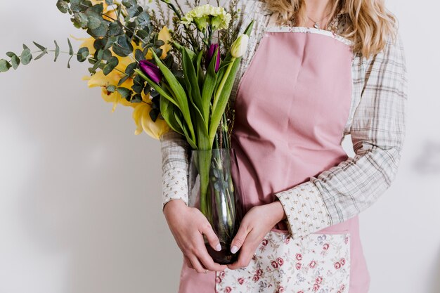 Crop Florist mit Blumenstrauß in der Vase