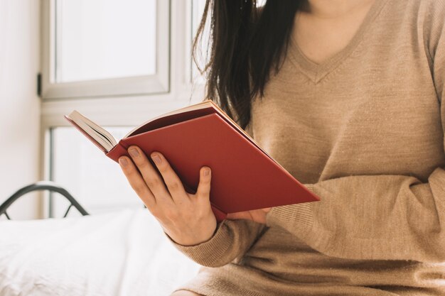 Crop Frau genießt das Lesen