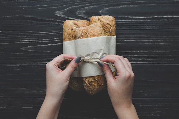 Kostenloses Foto crop hände binden faden um brötchen