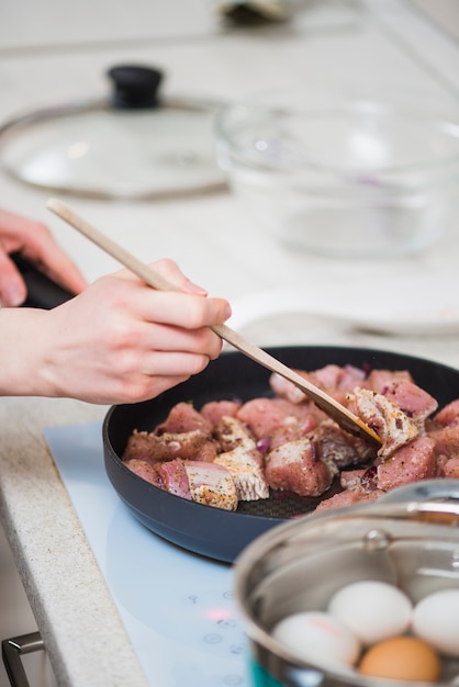 Crop Hände braten Huhn