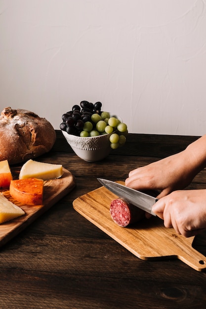 Crop hände schneiden geräucherte wurst