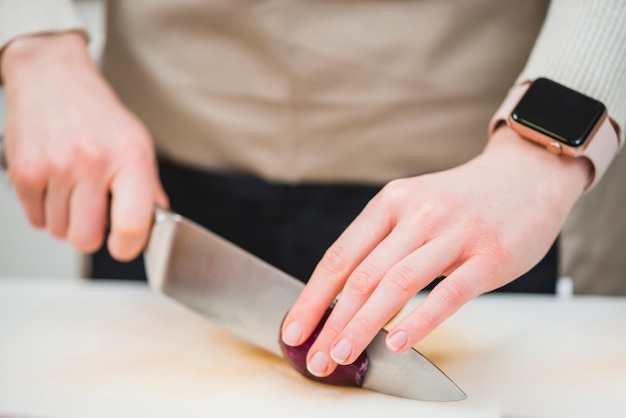 Crop Hände schneiden Zwiebel