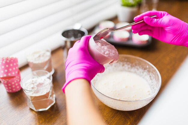 Crop Hände setzen Joghurt in Teig