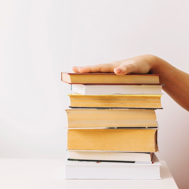 Crop Hand auf Bücherstapel