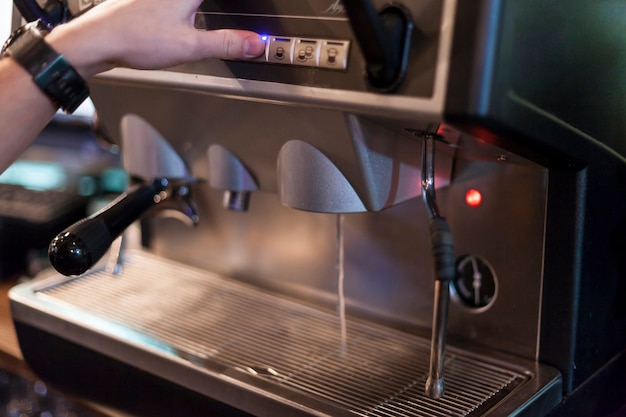 Crop Hand auf Kaffeemaschine