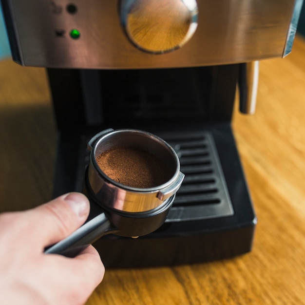 Crop Hand mit Kaffeefilter und Maschine