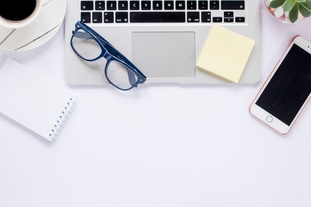 Crop Kaffee und Laptop in der Nähe von Smartphone