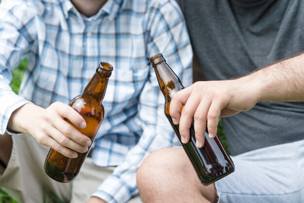Crop Männer mit Bier auf dem Rasen
