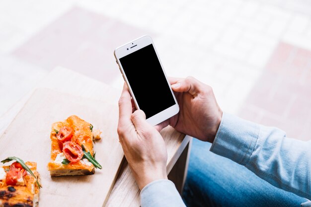 Crop männlichen Händen scrollen Smartphone-Bildschirm