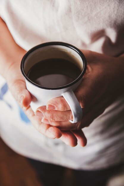 Crop Person mit Tasse Kaffee