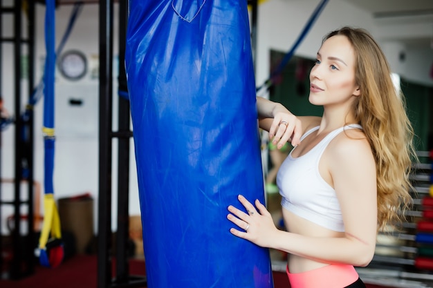 Crossfit Fitness Frau Boxen mit blauem Boxsack im Fitnessstudio