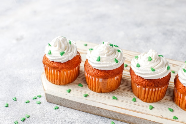 Kostenloses Foto cupcakes mit grüner dekoration auf holztisch