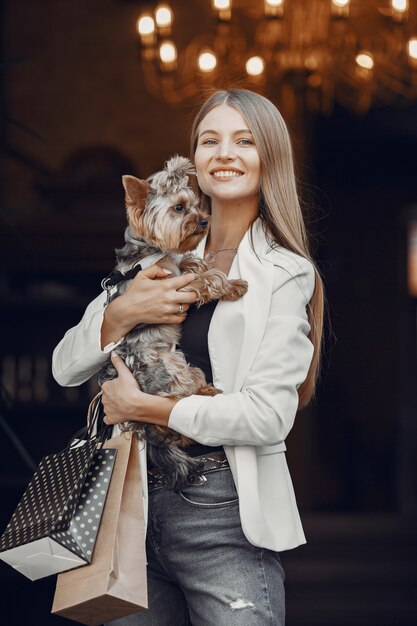 Kostenloses Foto dame beim einkaufen. frau mit niedlichem hund. frau mit einkaufstüten.