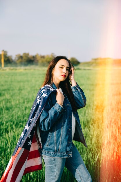 Dame, die auf dem Gebiet mit Flagge bleibt