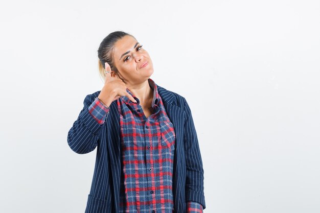 Dame, die Telefongeste in Hemd, Jacke zeigt und selbstbewusst aussieht. Vorderansicht.