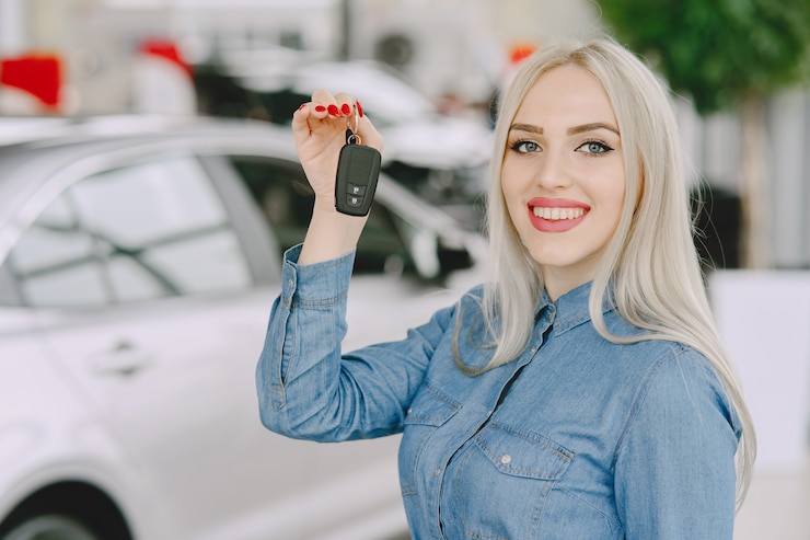 Kostenlose Foto dame in einem autosalon. frau, die das auto kauft. elegante frau in einem blauen kleid.