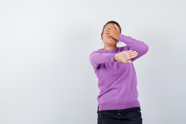 Dame in Wollbluse mit Stopp-Geste und verängstigtem Blick