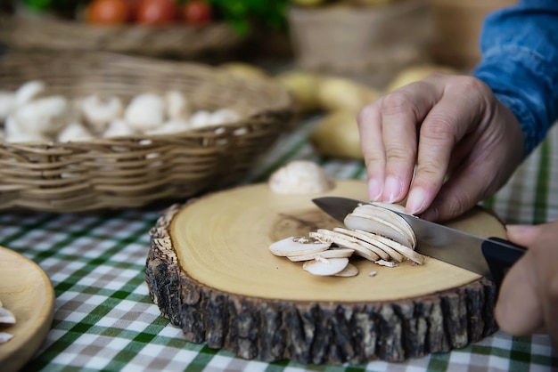 Dame kocht frisches Champignonpilzgemüse in der Küche