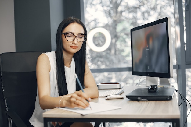 Dame mit Brille. Der Manager sitzt am Computer. Geschäftsfrau arbeitet in ihrem Büro.