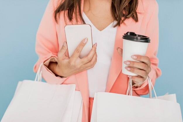 Dame mit Kaffee und Smartphone auf blauem Hintergrund