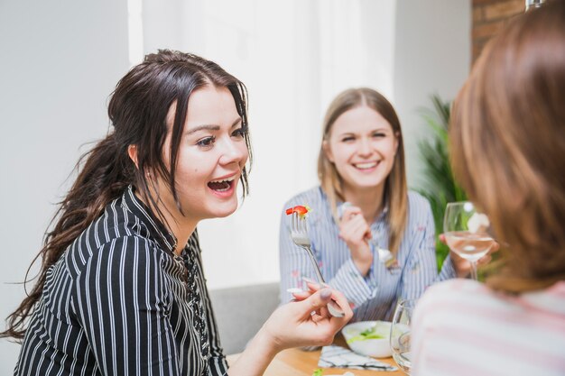 Kostenloses Foto damen, die zusammen zu hause trinken und essen