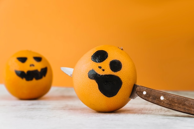 Dargestellte Zitrusfrucht mit Messer innen und eine andere Orange auf Hintergrund