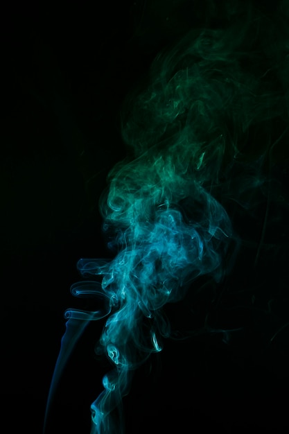 Das abstrakte muster aus blauem und grünem rauch steigt aus einem räucherstäbchen Kostenlose Fotos