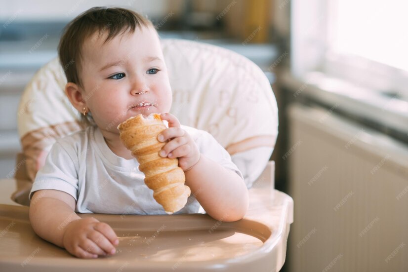 Das baby in der küche frisst gierig leckere cremige tuben