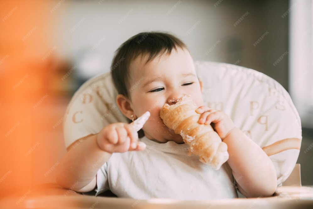 Das baby in der küche frisst gierig leckere cremige tuben