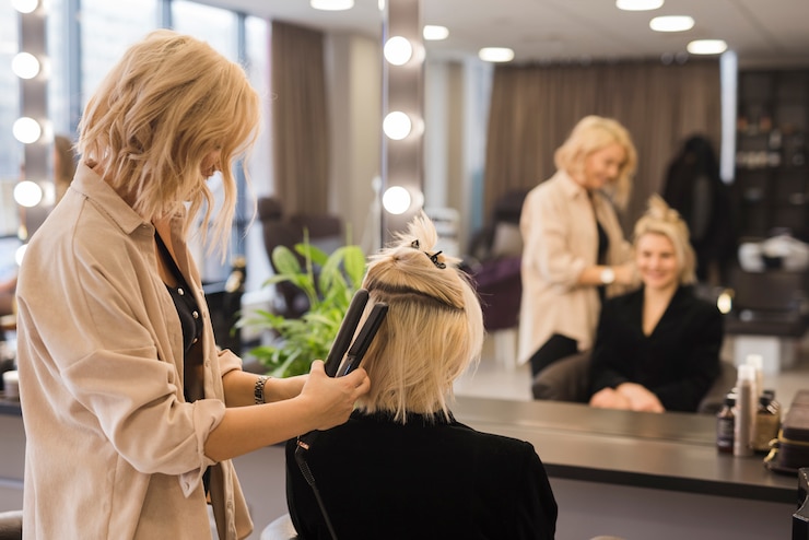 Kostenlose Foto das blonde mädchen, das sich die haare macht.