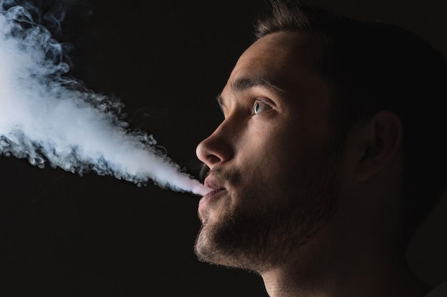 Kostenloses Foto das gesicht des dampfenden jungen mannes