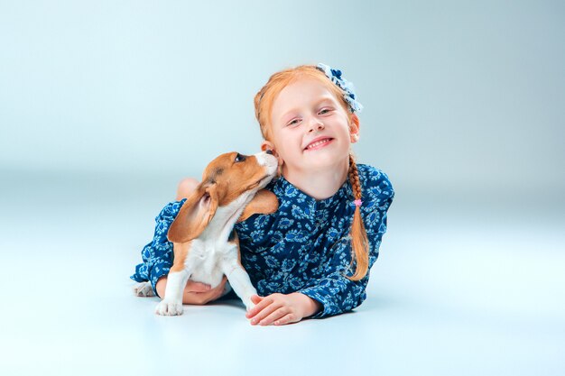 Das glückliche Mädchen und ein Beagle-Welpe