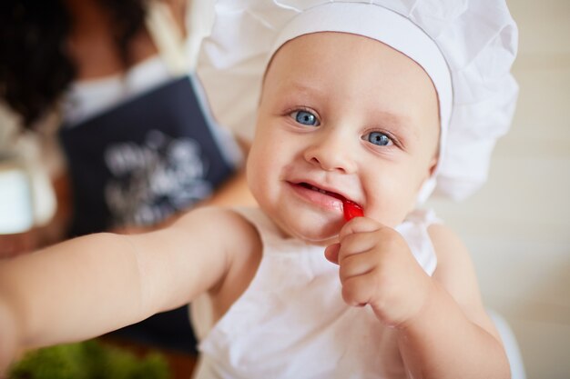 Das hübsche Baby, das ein rotes Papier isst