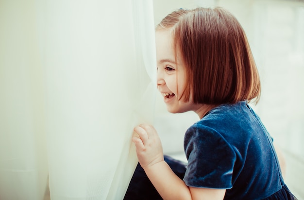 Das hübsche Mädchen sitzt auf der Fensterbank