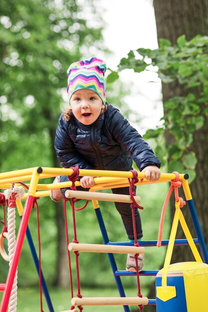 Das kleine Baby, das am Spielplatz im Freien spielt