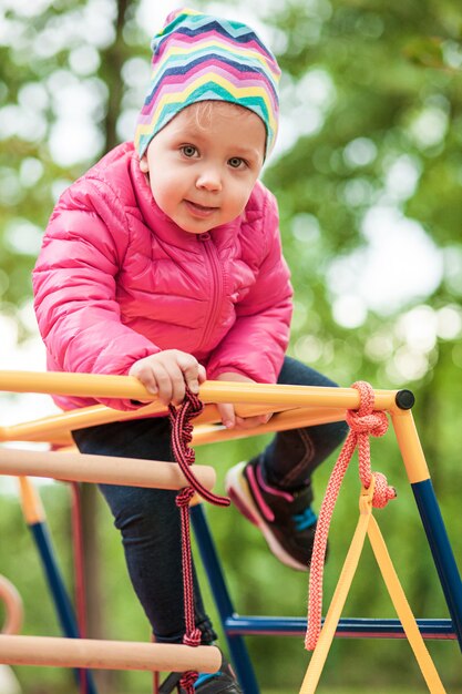 Das kleine Baby, das am Spielplatz im Freien spielt