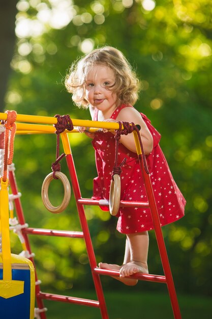 Das kleine Baby, das am Spielplatz im Freien spielt