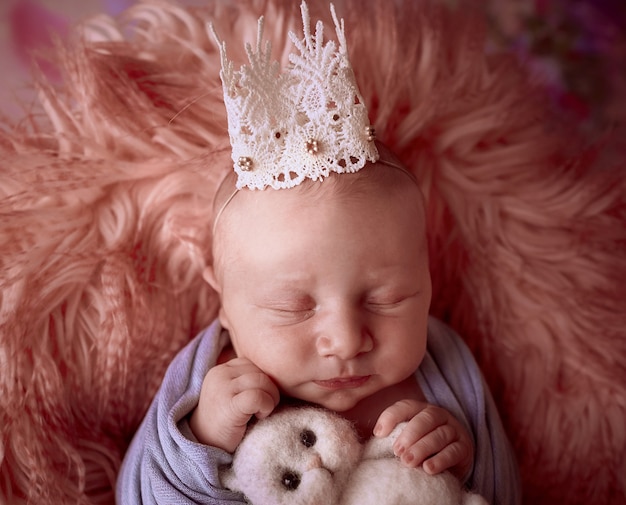 Kostenloses Foto das kleine baby mit krone liegt im korb