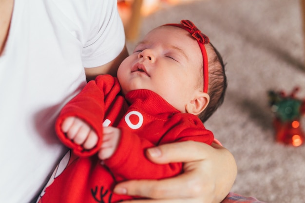 Das kleine Baby schläft auf den Händen der Mütter